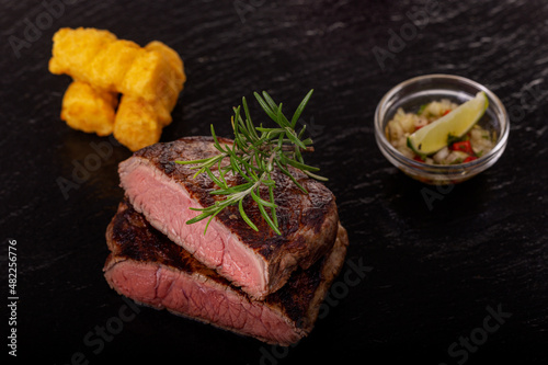 slices of grilled steak on black slate photo