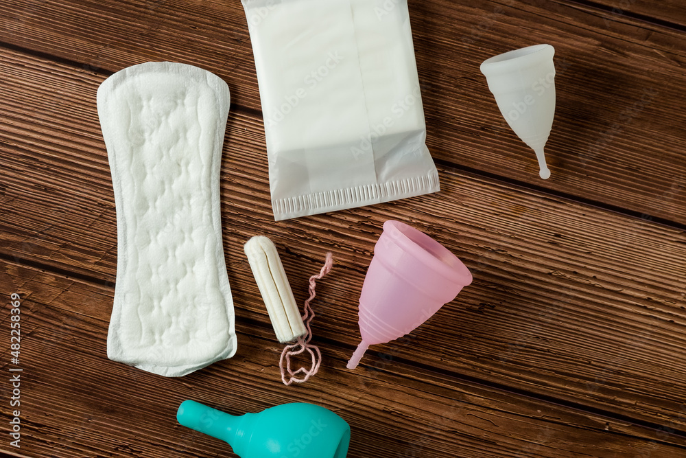 Different types of feminine menstrual hygiene materials products such as  pads cloths tampons and cups. wooden background. Menstruation and feminine  hygiene concept. Photos | Adobe Stock