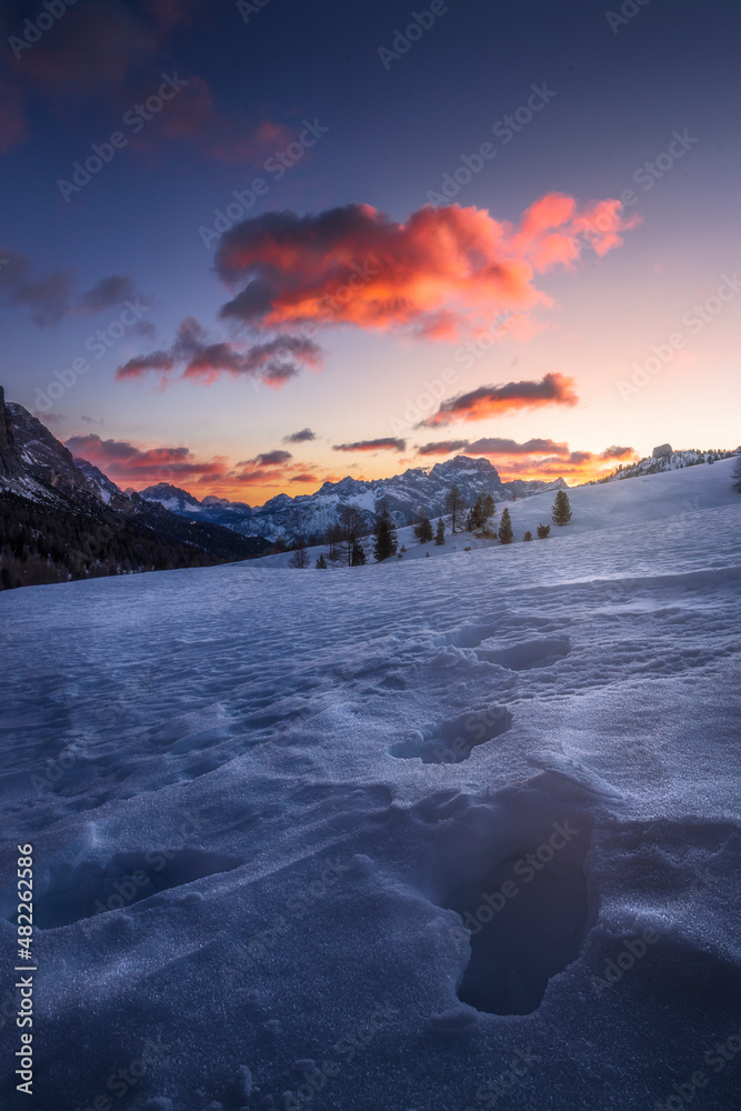 Pink clouds over a blue scenery at sunrise in Passo Falzarego, an alpine pass near Cortina d'Ampezzo, Dolomites, Italy