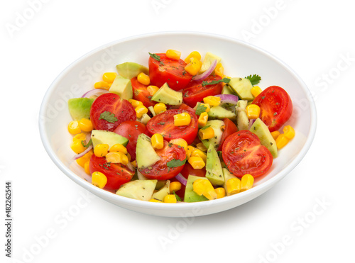 Avocado, tomato and corn salad in a white salad bowl isolated on white background.