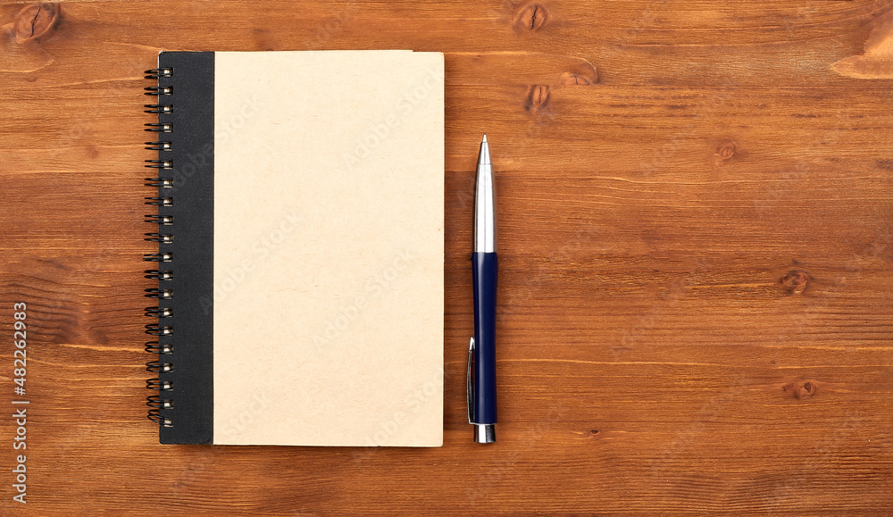 Blank notepad with kraft board cover, spiral and pen.Mockup