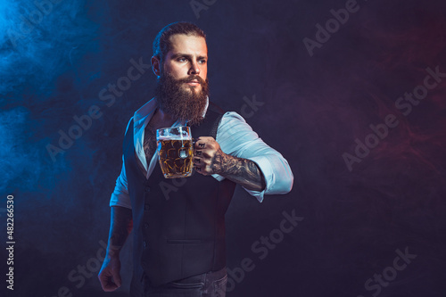 Portrait bearded man who holds tasty draft beer in hand. Drinking, October fest concept. 