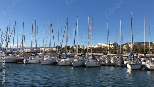 Different small boats moored in marina, blue sky and sea