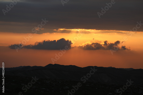 Beautiful sunrise of Judean Desert wadi, with sun rays breaking through clouds over the dry riverbed of Nahal Dragot popular hiking trail, winding towards the Dead Sea Israel. High quality photo photo