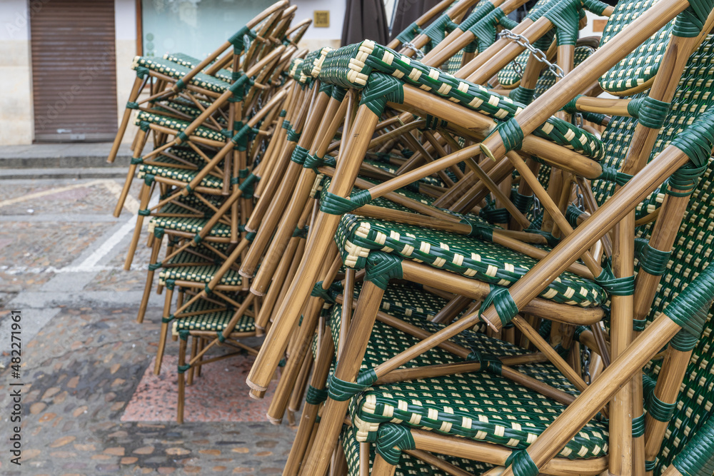 Chairs stacked at the entrance of a bar before starting the working day. Chairs stacked at the entrance of a bar before starting the working day.