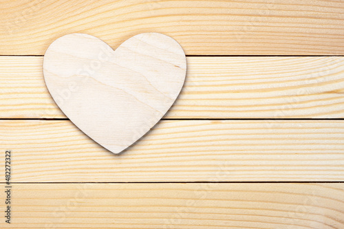 Plywood heart lies on the wooden boards