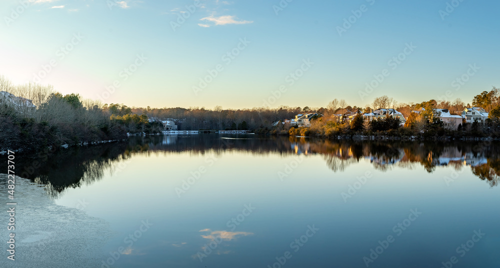 Houses by the Cary Lake Park under golden light sunset on a winter day