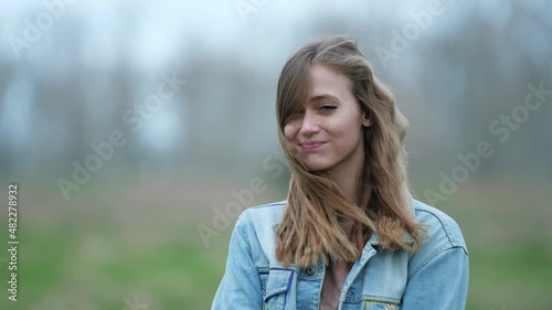 [4k] portrait of young blonde woman pouting in strong wind