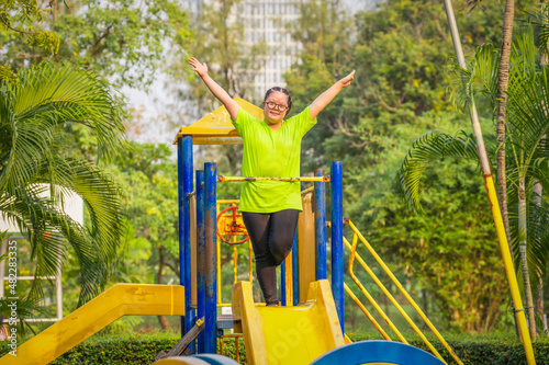 woman with autistic or down syndrome playing at playground in park