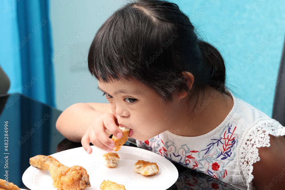 Southeast Asian child girl female special need medical down adhd autism syndrome eat food chicken Southeast Asian child girl female special need medical down adhd autism syndrome eat food chicken