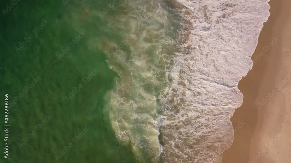 Aerial view of Barra da Tijuca Beach, a paradise in the west side of Rio de Janeiro, Brazil. Greenish sea waves and sand. Top view. Sunny day at dawn. Drone take. Aerial view of Barra da Tijuca Beach, a paradise in the west side of Rio de Janeiro, Brazil. Greenish sea waves and sand. Top view. Sunny day at dawn. Drone take.