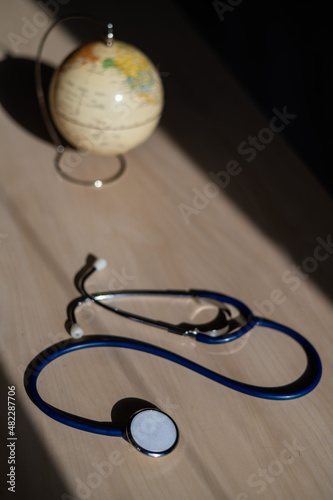 Globe and stethoscope. The concept of global warming and pollution. Phonendoscope and earth miniature. Stethophonendoscope. photo