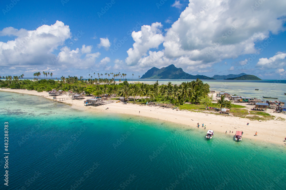 Aerial view of Maiga island panorama, beautiful blue lagoon and coral reef.