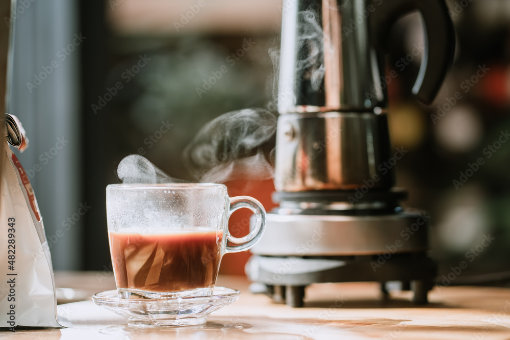 Coffee cup with vintage coffee maker moka pot background on wooden table at home office