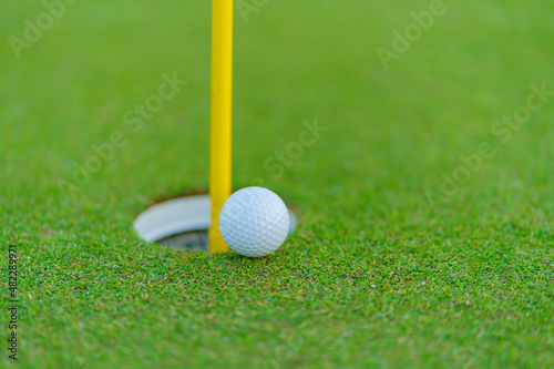 Golf ball on lip of cup at golf court