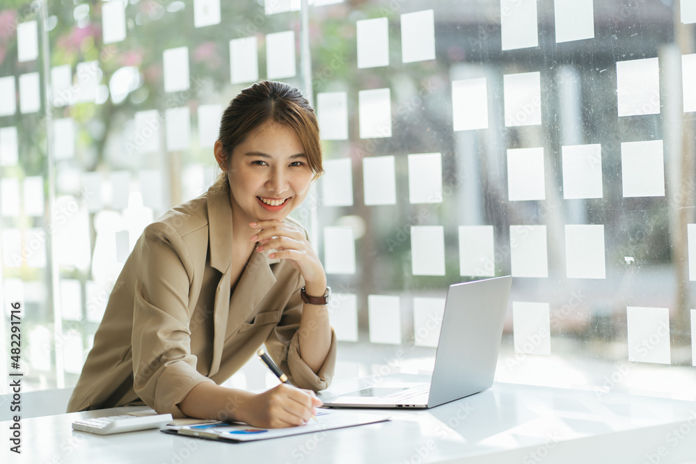 Asian woman working on a laptop computer,Working in the office with laptop concept,Young Asian woman starting a business using a laptop computer.