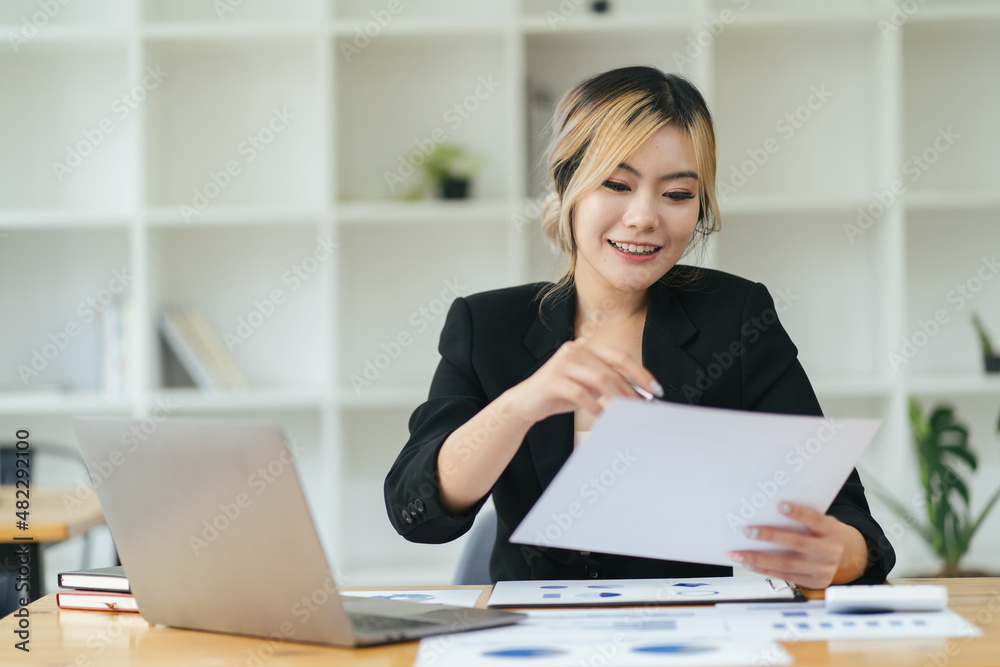 Pretty and charming asian businesswoman sitting happily smiling with laptop computer in the office. Pretty and charming asian businesswoman sitting happily smiling with laptop computer in the office.