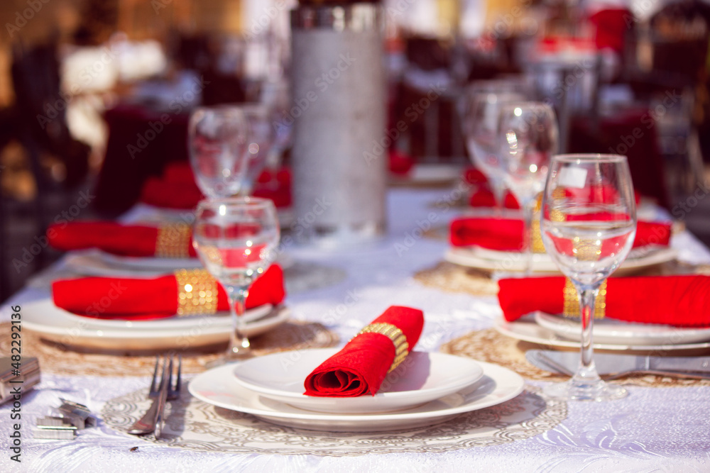 a beautiful decoration made with plates and red scarves along with the glasses