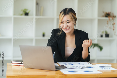 Beautiful Asian girl celebrate with laptop, success happy pose. E-commerce, university education, internet technology, or startup small business concept. Modern office or living room. © PaeGAG