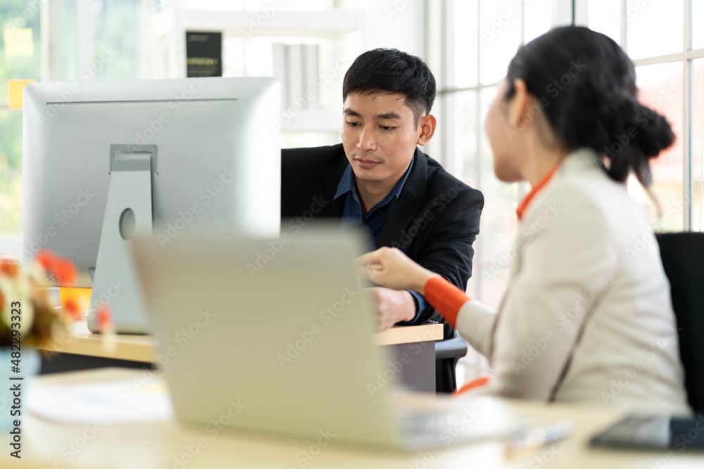 Asian business man and woman meeting analyzing and discussing strategy with startup project.Creative business people plan and brainstorm with laptop computer on conference in office.Teamwork Asian business man and woman meeting analyzing and discussing strategy with startup project.Creative business people plan and brainstorm with laptop computer on conference in office.Teamwork