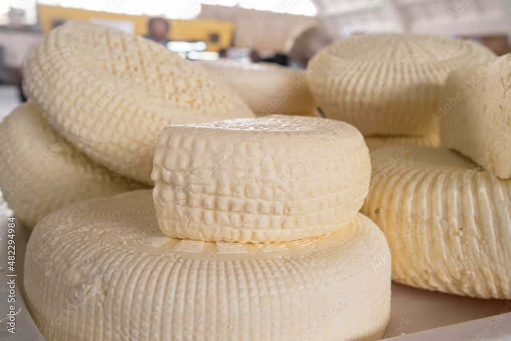 Closeup of piles of round homemade traditional cheese in the market in Georgia Closeup of piles of round homemade traditional cheese in the market in Georgia