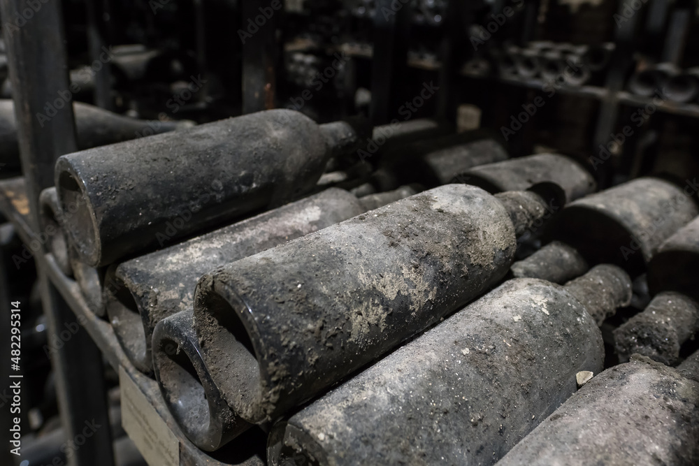 Very old dusty wine bottles in an underground cellar. Very old dusty wine bottles in an underground cellar.