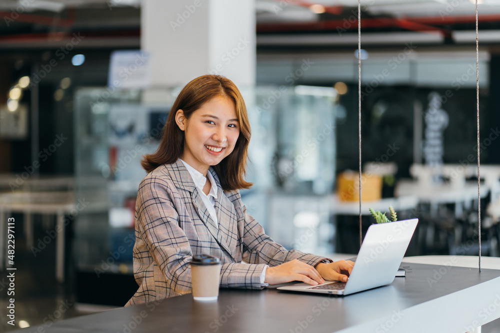 Asian woman working on a laptop computer,Working in the office with laptop concept,Young Asian woman starting a business using a laptop computer. Asian woman working on a laptop computer,Working in the office with laptop concept,Young Asian woman starting a business using a laptop computer.