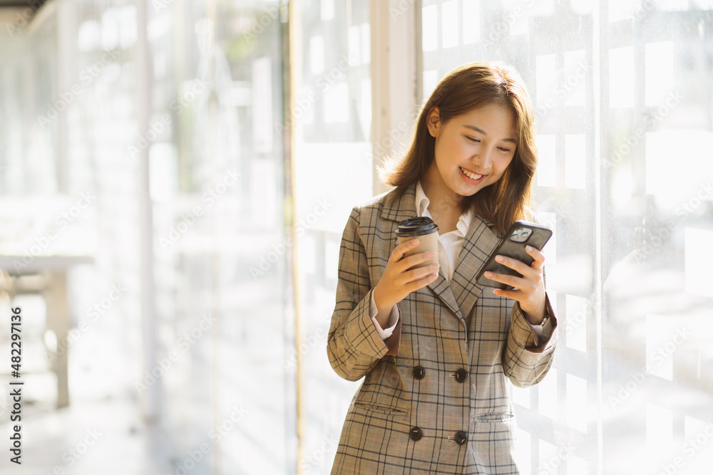 Businesswoman Outside Office On Mobile Phone with a cap of coffee. Businesswoman Outside Office On Mobile Phone with a cap of coffee.