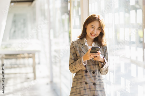 Businesswoman using cell phone, texting, smiling. Free Download Businesswoman using cell phone, texting, smiling. - GFXLoad