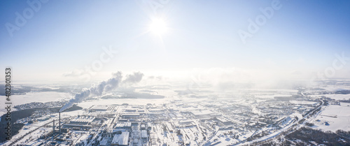 aerial panoramic view of urban industrial district, covered by snow on a sunny winter day