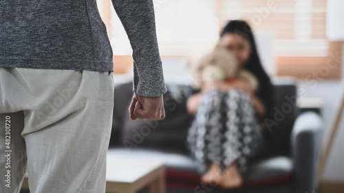 Aggressive man with clenched fist threatens to hit scared little girl. Domestic Family violence concept.