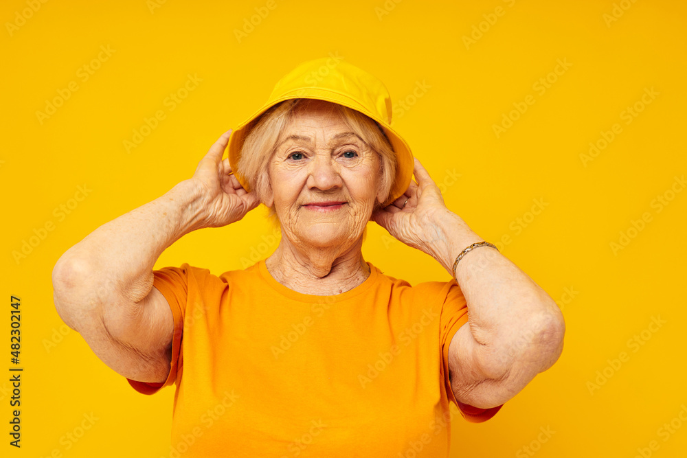 Photo of retired old lady in casual t-shirt yellow panama close-up emotions Photo of retired old lady in casual t-shirt yellow panama close-up emotions