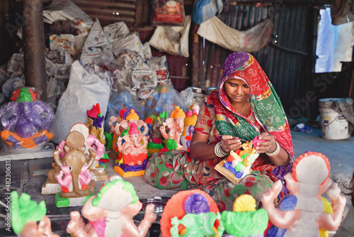 Indian Female worker painting the God Ganapathi statue for festival