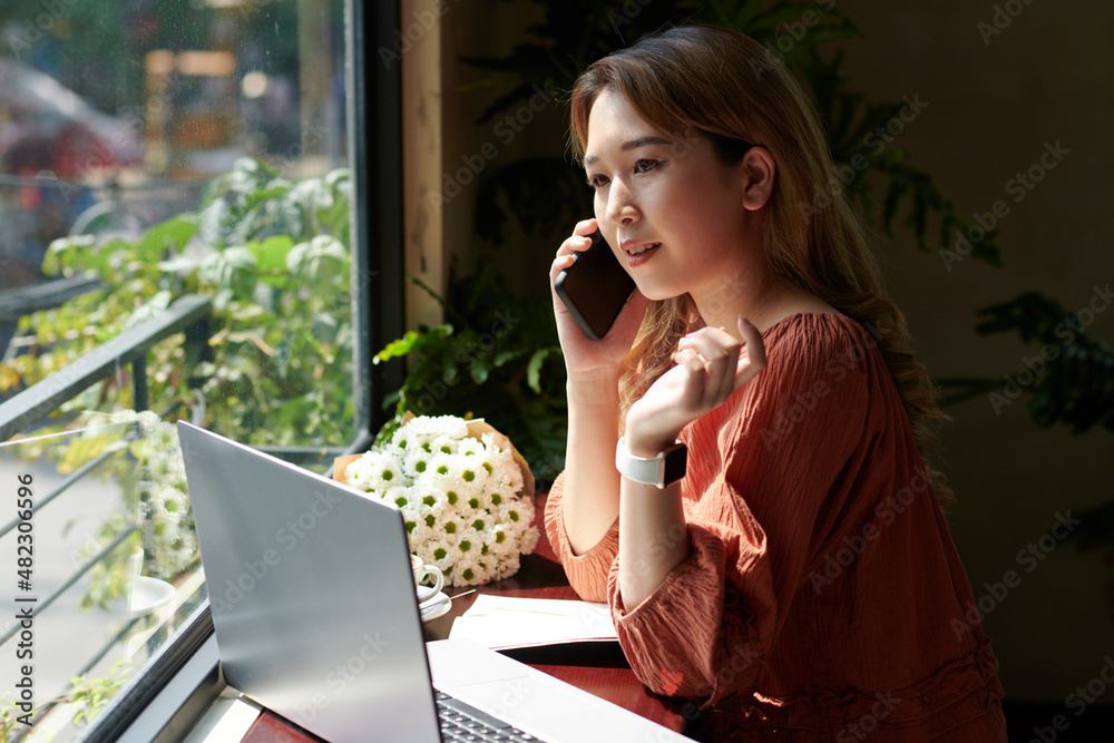 Young businesswoman answering phone calls when working at tablet in coffeeshop Young businesswoman answering phone calls when working at tablet in coffeeshop