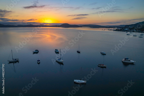 Sunrise waterscape with boats, soft clouds and reflections