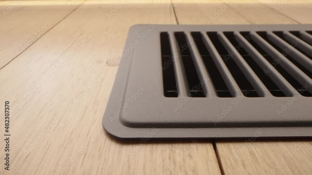 Motorized moving shot of ducted heating vent on hardwood floor, shot with macro probe lens