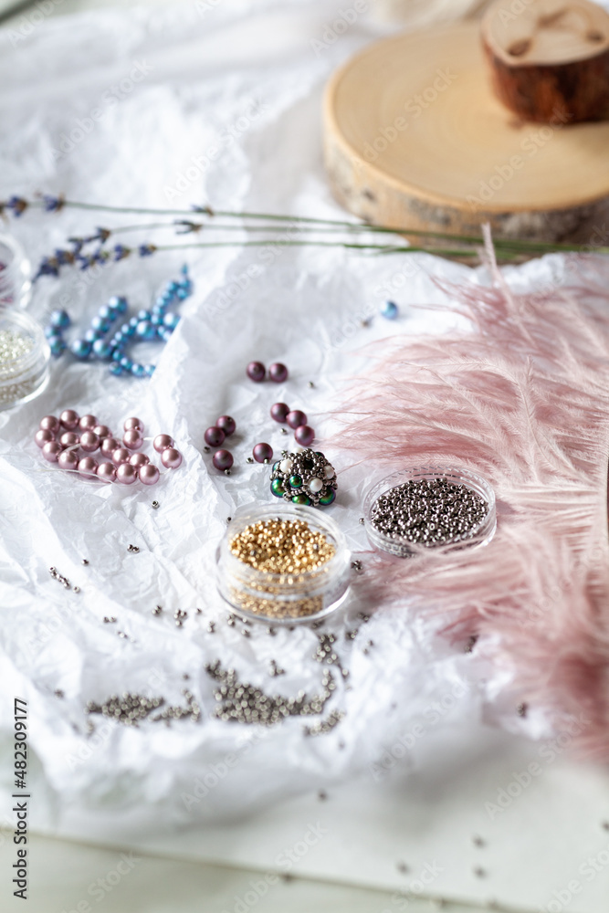 Colored beads and pearls scattered on a white table