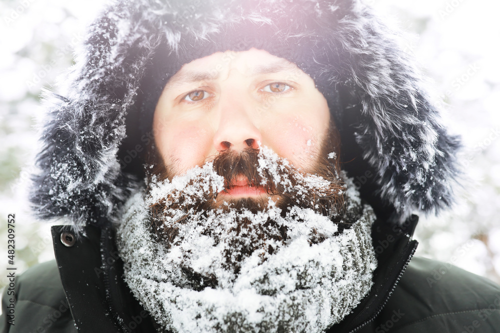 Outdoor portrait of handsome man in coat and scurf. Bearded man in the winter woods. Outdoor portrait of handsome man in coat and scurf. Bearded man in the winter woods.