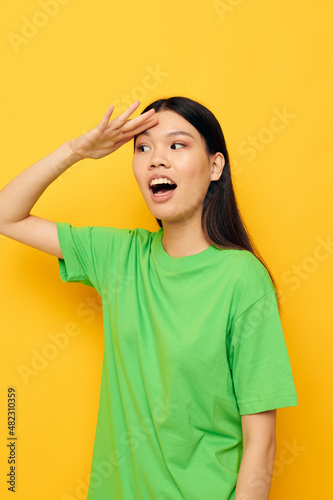 pretty brunette posing in green t-shirt emotions copy-space yellow background unaltered © Tatiana