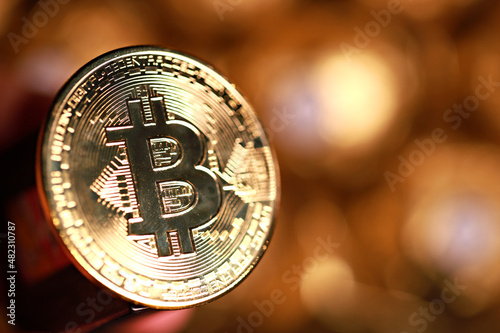 Bitcoin gold coin and defocused background. Virtual cryptocurrency concept. Soft focus image