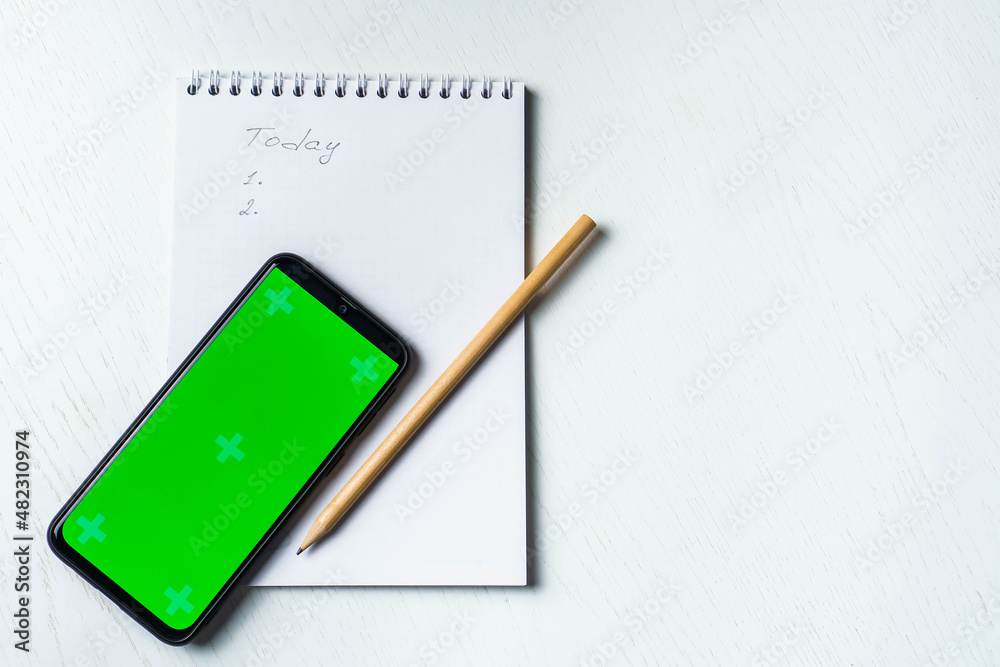 White notepad with inscription today, smartphone green screen mockup and pencil flat lay. Tamplate for design White notepad with inscription today, smartphone green screen mockup and pencil flat lay. Tamplate for design