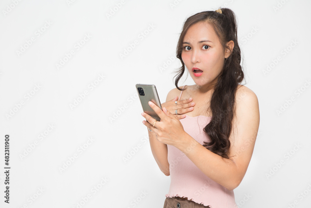 Cute Asian woman is shocked something on her smartphone for social media concept Cute Asian woman is shocked something on her smartphone for social media concept