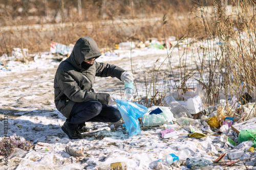 volunteer collects garbage in a bag on the street, the concept of environmental protection