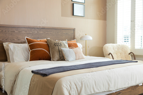 Red brown tone bedroom with wood wall , carpet and armchair. big bedroom and window.