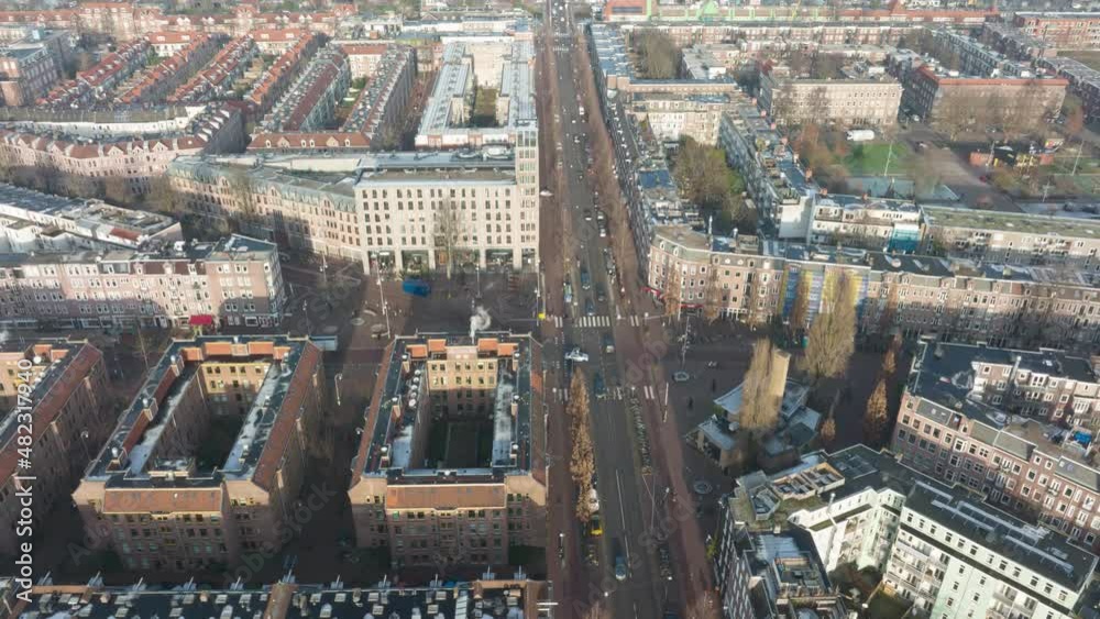 Aerial hyperlapse of the Javaplein square in Amsterdam East, busy urban city life at an intersection with trams pedestrians cars and cyclists.