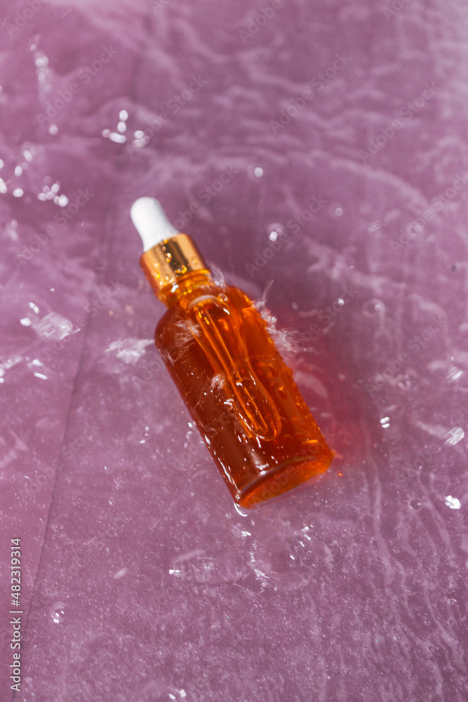 Fototapeta premium glass cosmetic bottle on the background of water. Beauty blog, the concept of sustainable brand packaging