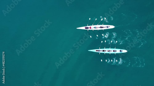 Aerial drone bird's eye view video of two sport canoe operated by team of young men and women . High quality 4k footage photo