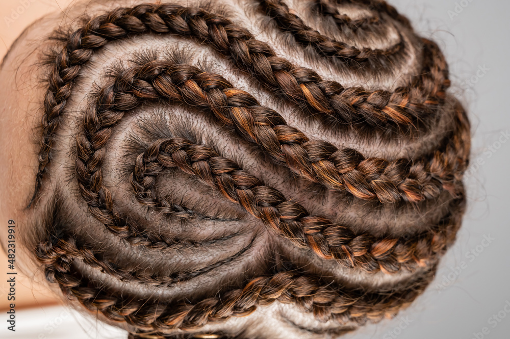 Close-up of braids on the head of a caucasian woman. - obrazy, fototapety, plakaty 