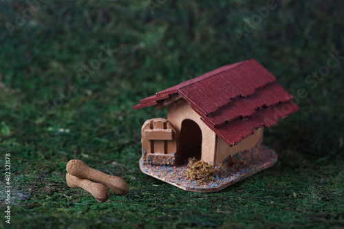 doghouse and two bones on green background. Image contains copy space