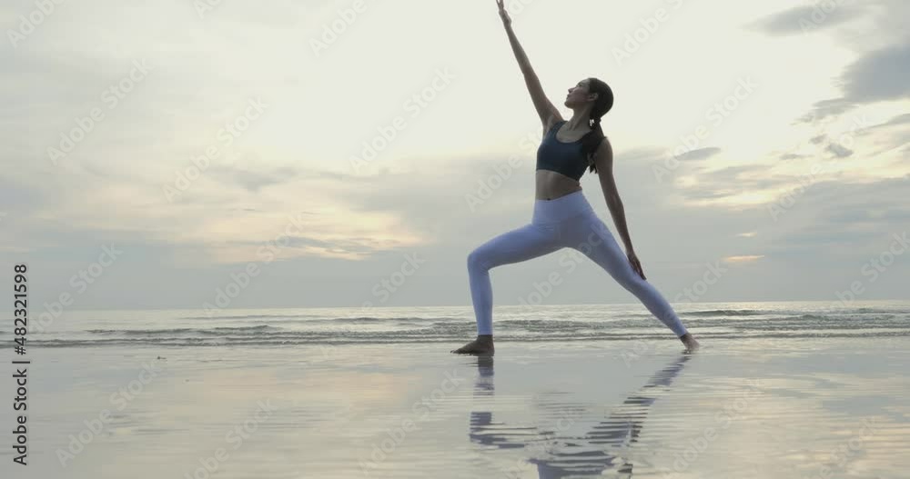 Young woman doing yoga at the beach. She practice yoga in beautiful beach sky. Healthcare and Exercise concept. Young woman doing yoga at the beach. She practice yoga in beautiful beach sky. Healthcare and Exercise concept.